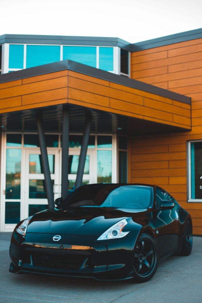 blue porsche 911 parked in front of white and brown building